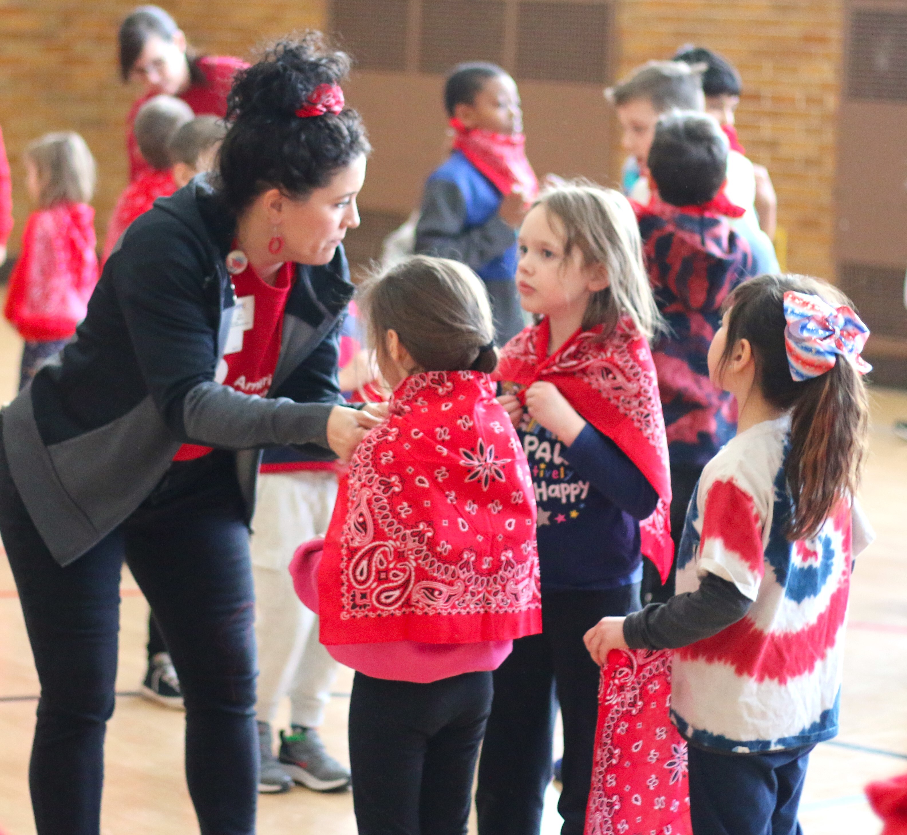 Kim Baron assists North Park Montessori students with their new bandanas
