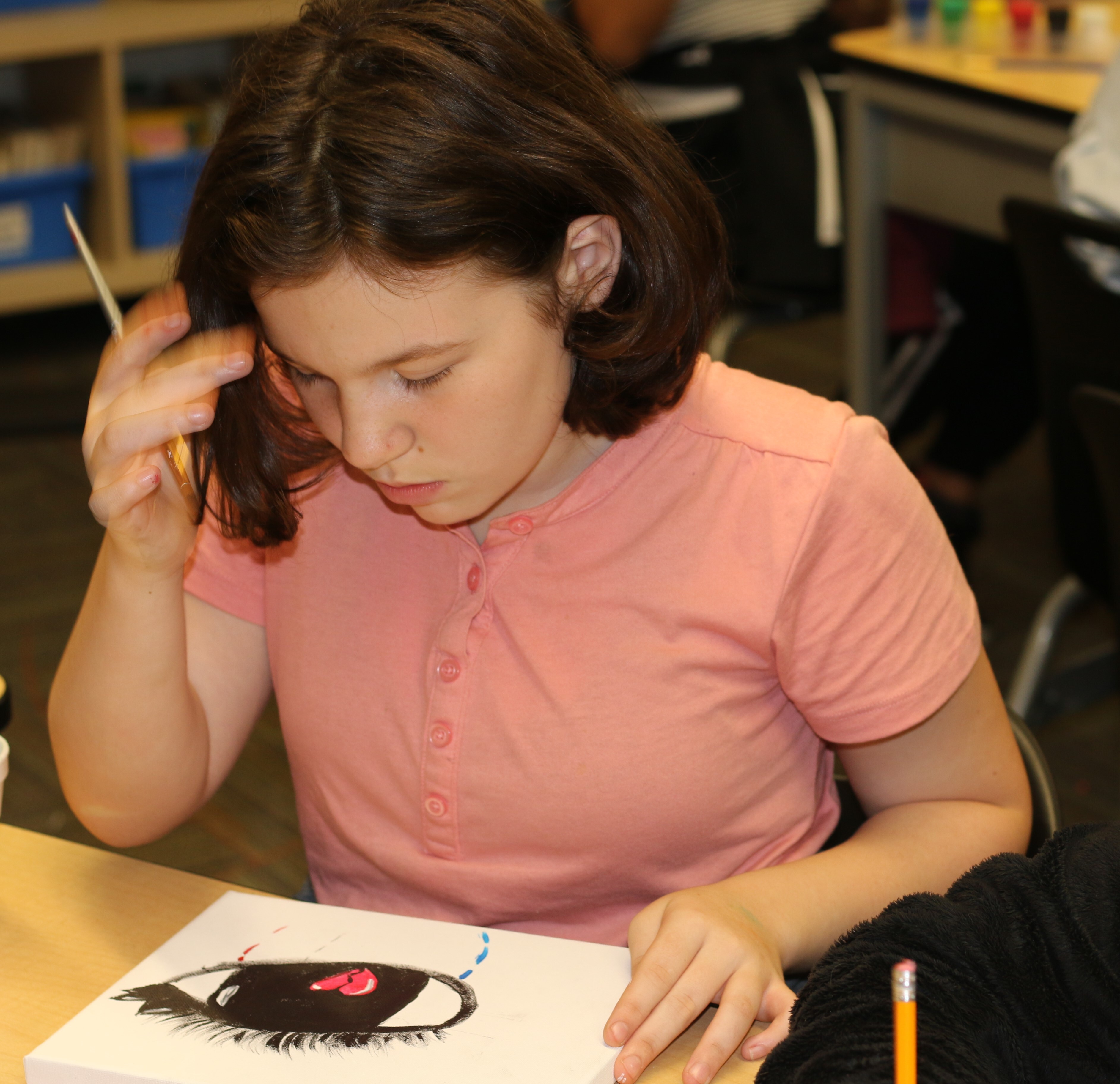 A scholar artist at César E. Chávez Elementary ponders her work
