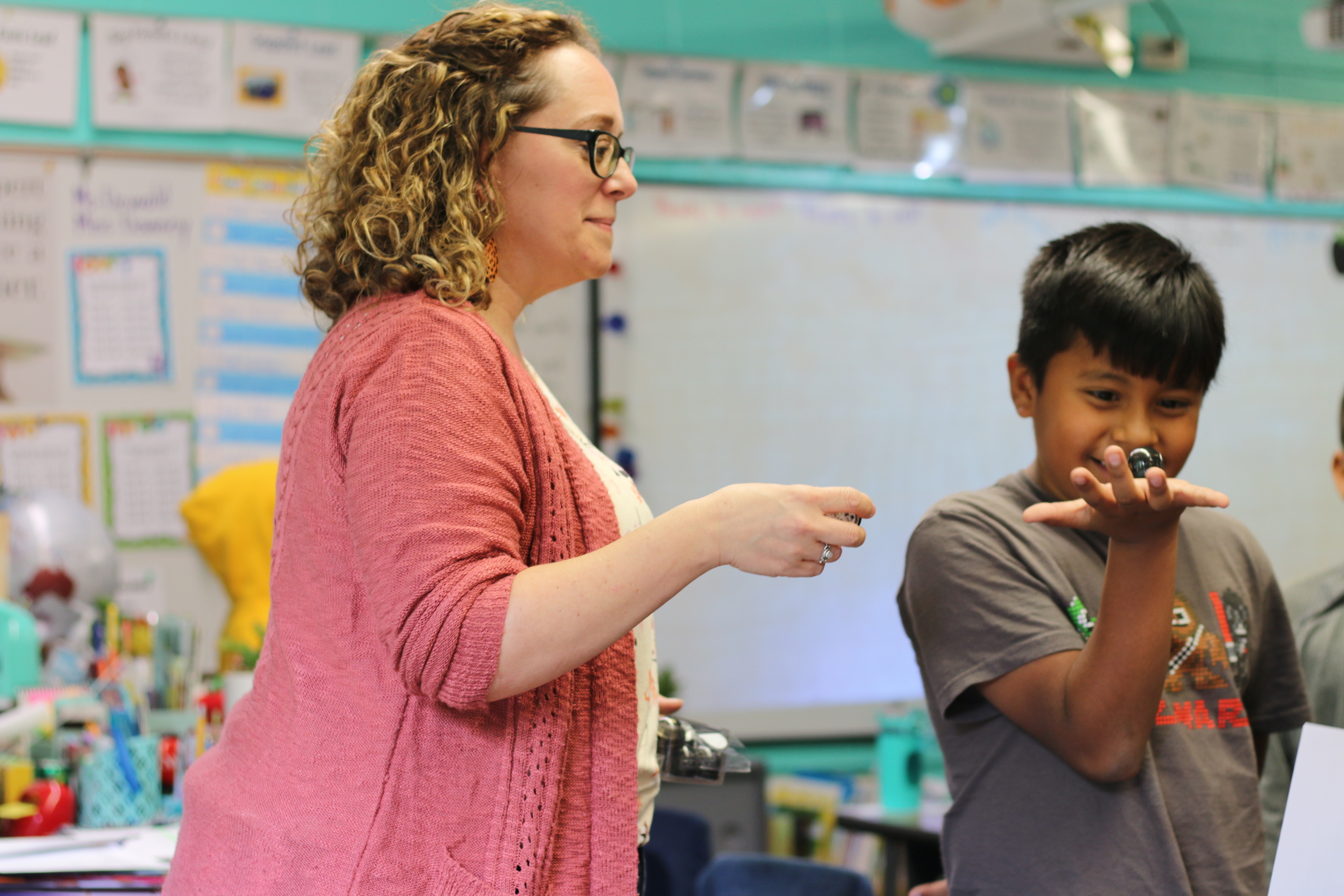 Shawmut Hills third-grade teacher Jennifer Dewald gives a student an Ozobot ahead of a Friday-afternoon robot party