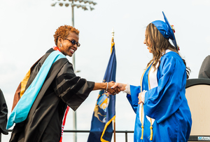 GRPS Superintendent Dr. Leadriane Roby shakes the hand of a graduating City High School scholar.