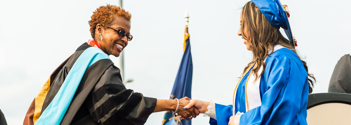 GRPS Superintendent Dr. Leadriane Roby shakes the hand of a graduating City High School scholar.